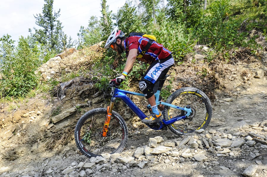 Off Road cyclist on rocky terrain riding downhill.